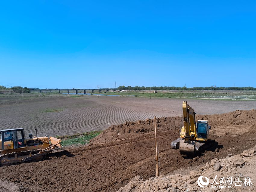 兩臺(tái)工程車“加培”堤防忙不停。人民網(wǎng)記者 馬俊華攝