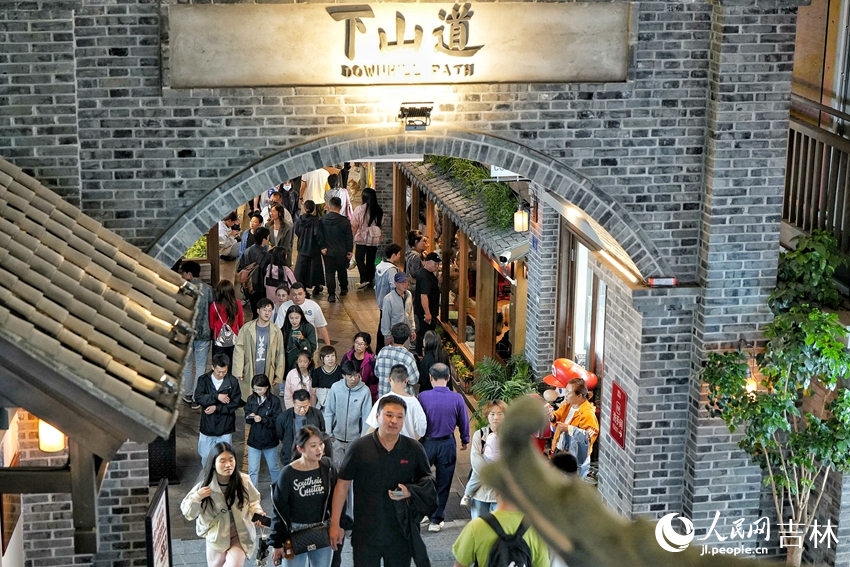 夜色降臨,游客在位于長春市的“這有山”文旅小鎮逛街購物。人民網記者 李洋攝