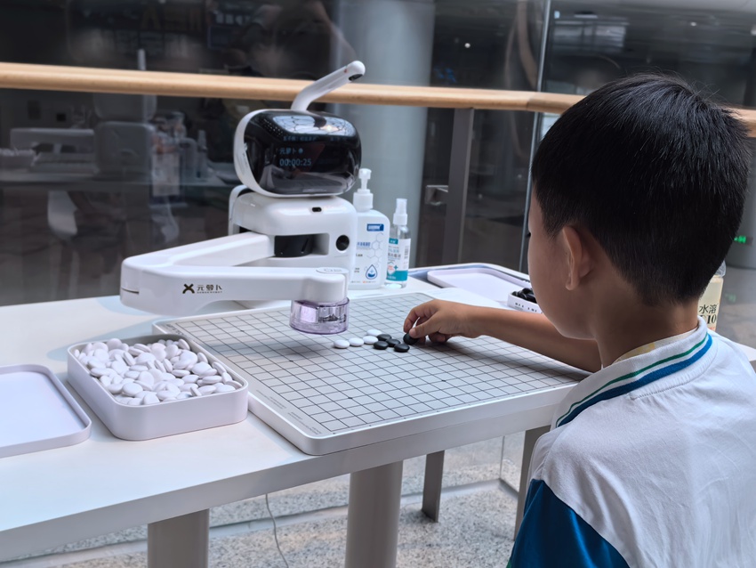 小朋友和機器人下五子棋。人民網(wǎng)記者 王海躍攝