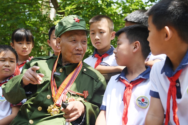 老兵楊建為孩子們講述自己在戰場上的經歷。