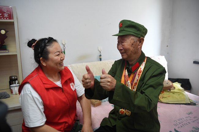 老兵朱萬金向關愛老兵志愿者表達感謝。