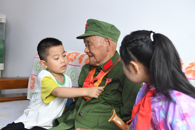 老兵李文惠為孩子講述自己的戰斗故事。
