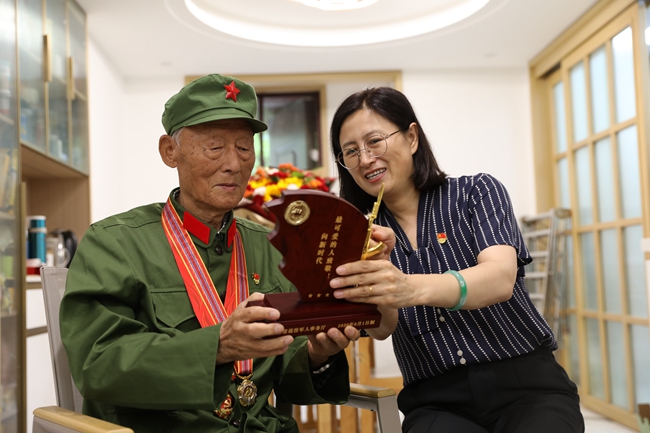 志愿者為老兵安福英贈送榮譽激勵牌。