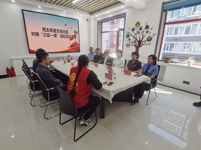 敦化市司法局局長高純軍與敦化市民主街黨工委書記庚輝落實“三官一律”進社區工作