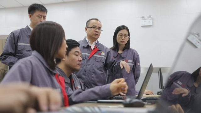 朱彥（右二）和團隊開展動車組研發工作。（中車長春軌道客車股份有限公司供圖）
