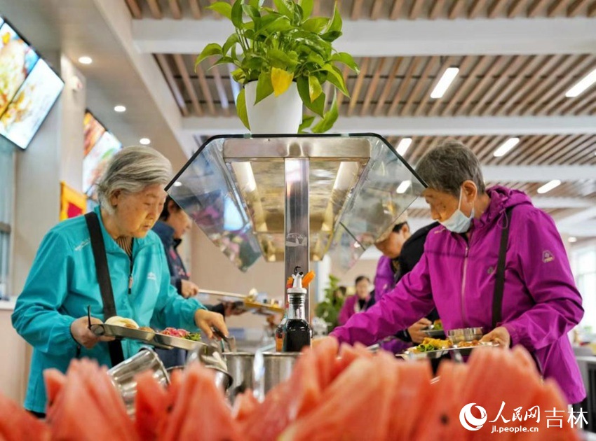 長春市飛躍街道三佳社區敬老餐廳內，市民正在選取午餐。人民網記者李洋攝