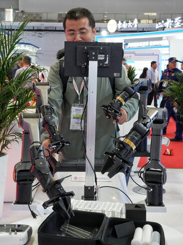 游客在操作開源雙臂遙控系統。人民網記者 李洋攝
