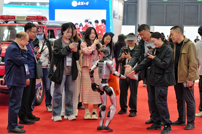 博覽會現場，游客們與人形機器人握手互動。人民網記者 李洋攝