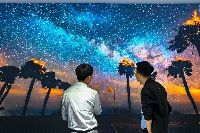 長春光博會希達電子展區,一位工作人員正在給一位觀眾講解。(長春新區供圖)