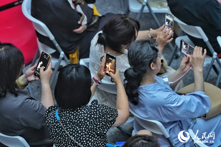 觀眾們紛紛舉起手機(jī)記錄下這難忘的瞬間。人民網(wǎng)記者 李洋攝