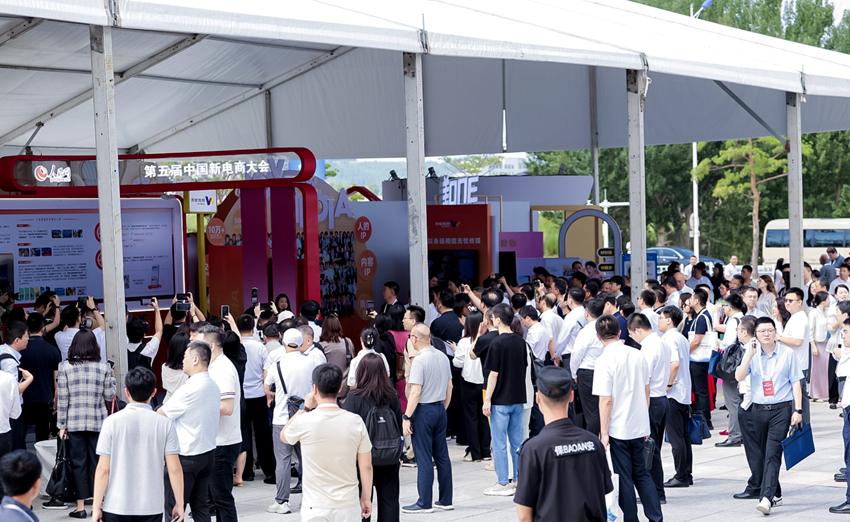 開幕式前，與會嘉賓在人民優選、抖音等展位前，與工作人員交流新電商發展（主辦方供圖）