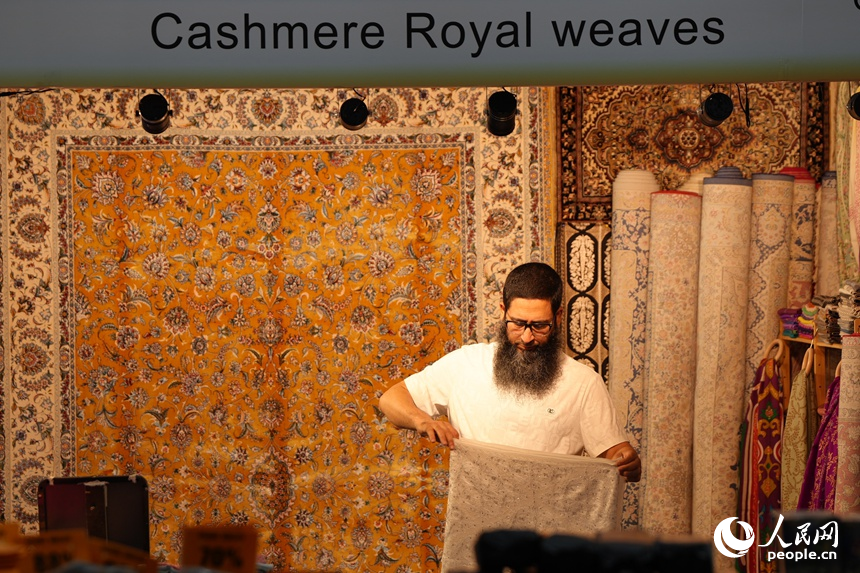 在第十五屆中國—東北亞博覽會(huì)國際館，一名外國參展商正在整理商品。人民網(wǎng)記者 李洋攝