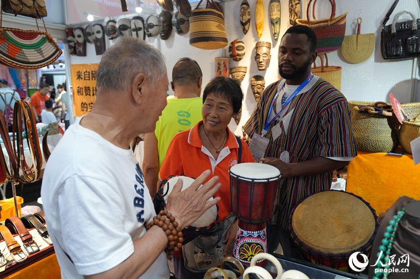 游客在第十五屆中國—東北亞博覽會上試用金貝鼓。人民網記者 李洋攝