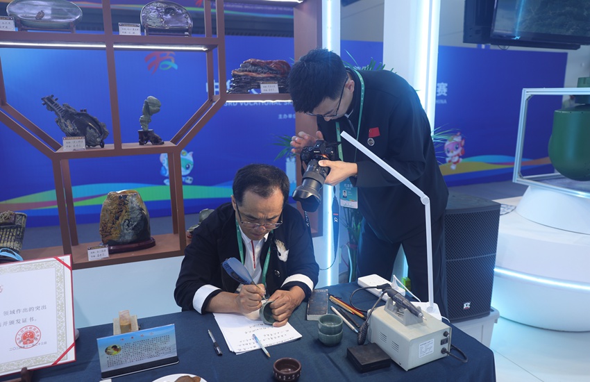 吉林省工藝美術大師、省級非遺傳承人竇茂忠認真雕刻著手中的松花石。不一會兒工夫，一個個精美的字組成極具韻味的詞句，躍然“石”上。楊宜修攝