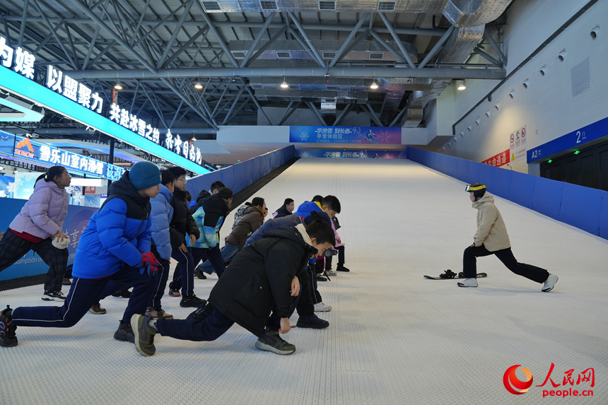 雪博會上，青少年在進行滑雪前的熱身運動。人民網記者 李洋攝