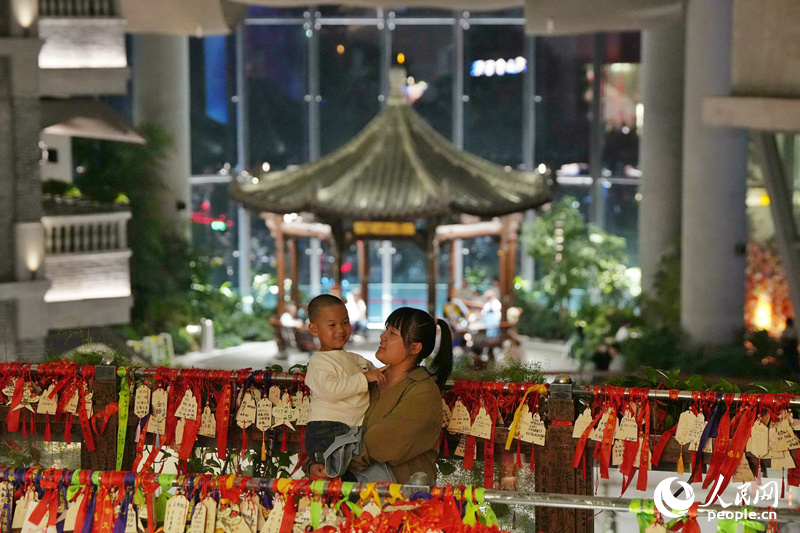 3月，長春“這有山”文旅綜合體人氣十足，一對母子在商場內合影留念。“這有山”位于長春市朝陽區，是吉林省地標性文旅項目。近年來，長春市圍繞吃穿住用行等傳統消費和服務消費，培育出一批帶動性廣、顯示度高的消費新場景。人民網記者 李洋攝