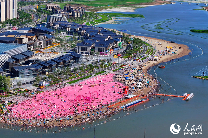 8月，長春肆季南河岸線公園的粉色沙灘人氣十足。肆季南河是長春首個濱河文旅商綜合體，項目依托“一河兩岸三橋”格局，打造多元業態于一體的潮流空間。人民網記者 李洋攝