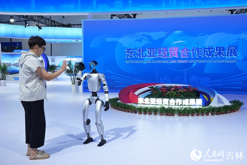 第十五屆中國—東北亞博覽會上，游客與機器人擊掌。人民網記者 李洋攝