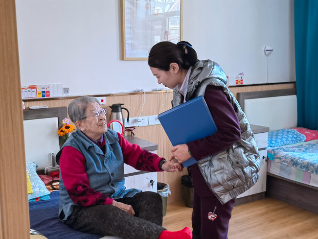 養老院工作人員與老人聊天談心。人民網記者 馬俊華攝