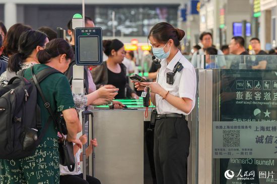 2023年10月1日，上海虹橋站，鐵路工作人員正在人工檢票。 人民網(wǎng)記者 王初攝